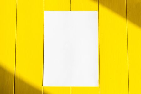 Rough shadow. Retro style wooden background on wooden background. A sheet of white paper in the center.の写真素材