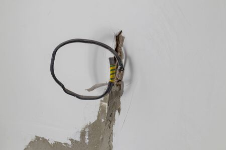 Plastered white wall. It displays a cable for connecting outlets. Copy space. Close-upの写真素材