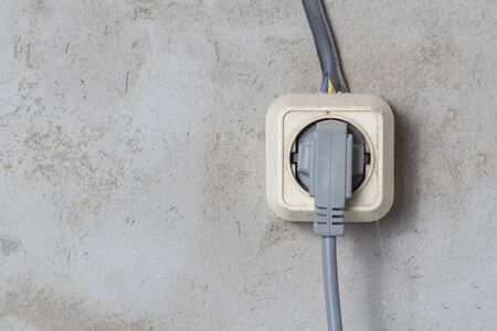 Electric sockets light works mounting and installation on plaster wall background. Professional...