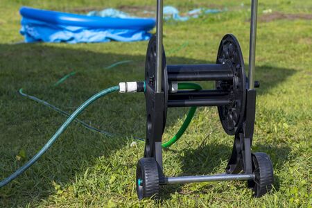 the hose is connected to water. The coil is in focus. In the background, the pool is filled.の写真素材