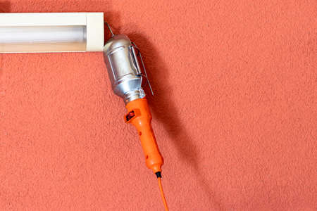 garage. Concrete walls to be painted. An orange carrier hangs on it for inspection of the car and...
