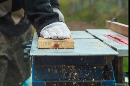 Daylight. machine for sawing wood. The master hands the board, the planed board. Close-upの写真素材