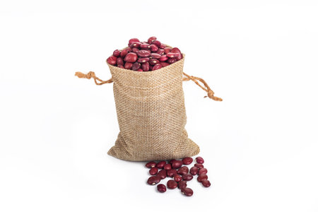 Studio lighting. red beans in a linen bag on a white background. There is a shadow. Close-up. No isolationの写真素材
