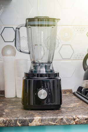 Natural light. black food processor. Near the nozzle for use. In the background is a kitchen for cookingの写真素材