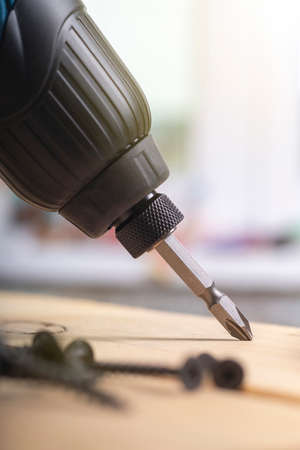 studio lighting. electric impact screwdriver. Wooden background in retro style. Soft focus. Close-upの写真素材