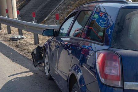 street lighting. the blue car crashed into a metal fence. Close-up.の写真素材