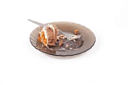 Studio lighting. a cinnamon plate on top of it is a piece of cake and a fork to eat. On a white...