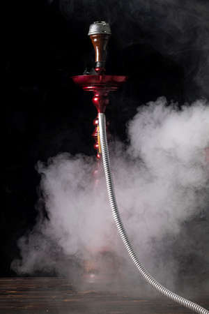 close-up. Hookah with a glass flask and a metal bowl hookah, there is a smoke of smoke. Black...