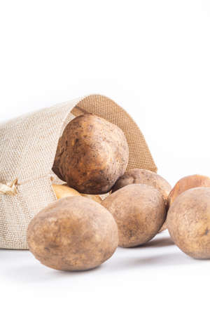studio lighting. white background. potatoes are planted from a bag in a retro style. close-up.の写真素材