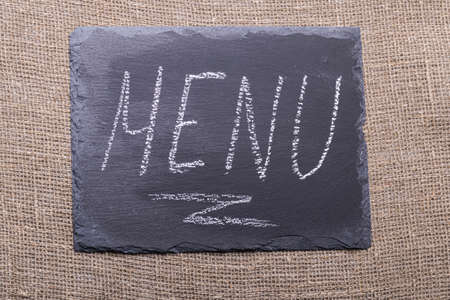 menu. an inscription on a black stone in white chalk. taken on burlapの写真素材