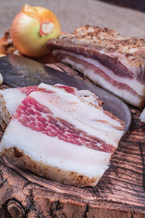 small depth of field. lard layer sprinkled with spices on top. next to the onion head. a kitchen knifeの写真素材