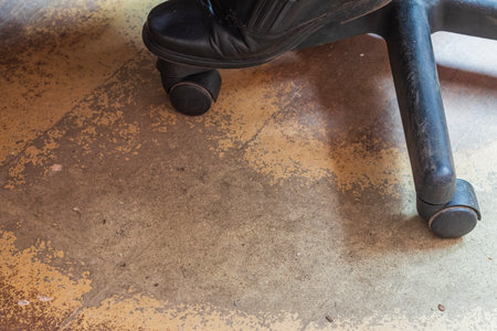office. the man in the chair. close-up. legs. damaged laminate. The concept of an employee has been working for a very long time and a lot of workの写真素材