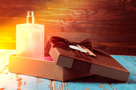 shooting in the studio. artificial light. perfume bottle on a wooden background in retro style. next...