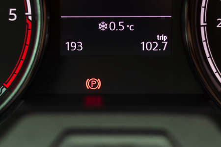 soft focus. natural light. the dashboard. the parking indicator lights up.