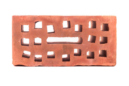 white background. the brick was made of clay. there are holes. close up