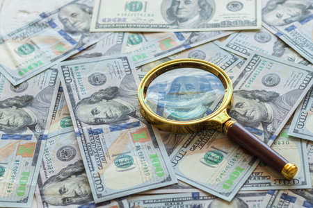 one hundred dollars. a magnifying glass in a gold frame. close up.の写真素材
