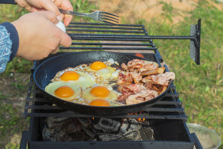 natural light. barbecue. a frying pan is used for cooking. fire. firewood. picnic.の写真素材