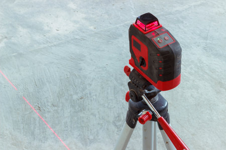 soft focus. construction site. Red laser level, on a tripod. turned on in a dark room