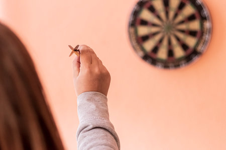 natural light. soft focus. a human hand holds a dart. playing darts.の写真素材