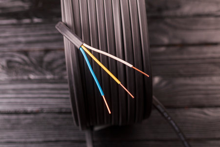 wooden, dark background. cable for wiring electrics in a country house and industrial facilities....