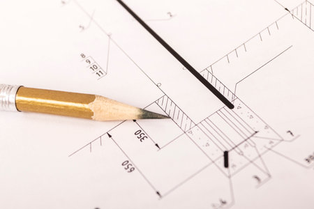 A graphite pencil lies on a piece of paper where there is a house project. close-upの写真素材