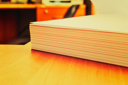 Stacks of white papers on a desk in an office. Documents that are yet to be printed or made. Business concept.の写真素材