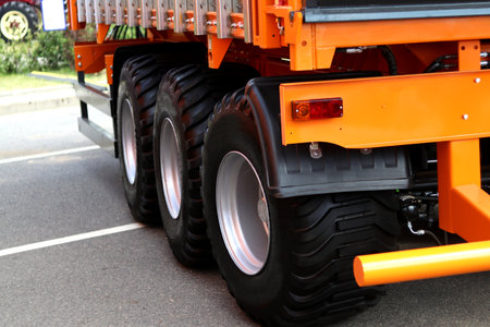 Dump truck wheels with all-season tires on an asphalt road. Close-up of the rear axles of the truck