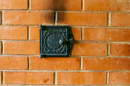 door to the firebox. natural light. not a large room. the stove for heating and warming is lined...