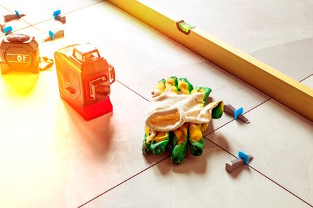 Laying floor tiles. Linear level. Green hand glovesの写真素材