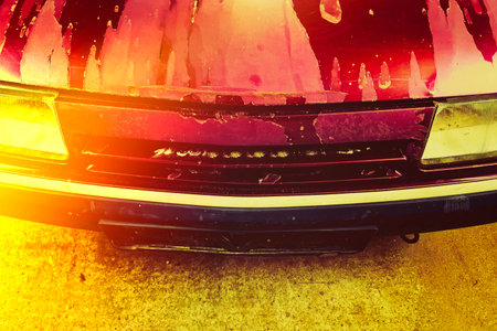 Old vehicle with worn headlight close-up in a garage during daytimeの写真素材
