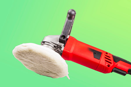 Close-up of a polishing machine designed for automotive detailing. The tool features a wool pad,...