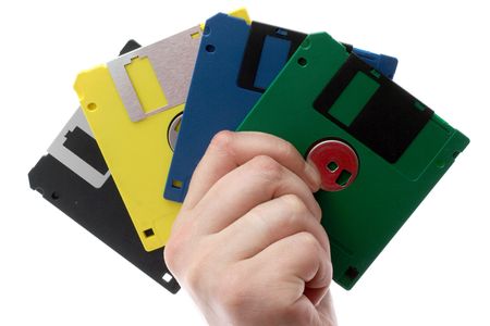 The hand holds some multi-coloured diskettes on a white backgroundの写真素材