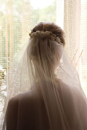 The girl standing near the closed windowの写真素材