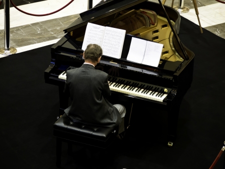 senior man playing on a grand piano, from back viewのeditorial素材