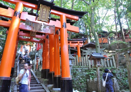 KYOTO, JAPAN - OCT 23 2012: A tourist at Fushimi Inari Shrine on October 23 2012. The shrine is famous for its torii gates walkway that lead to the top of the mountain.のeditorial素材