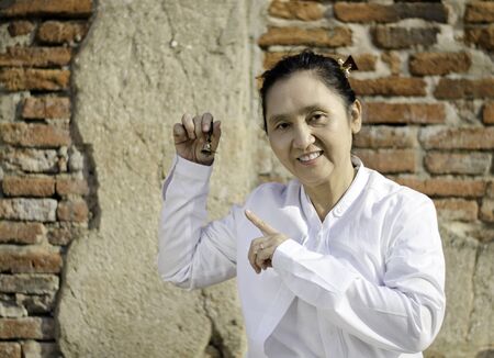Asian woman playing a bell, traditionally used to aid meditation in Buddhist cultures  