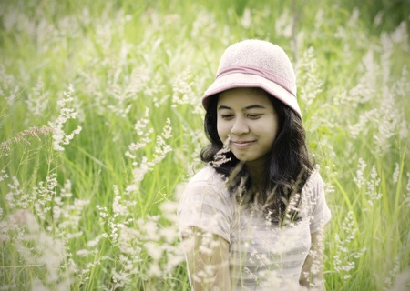 Young brunette woman on the meadow with white flowers on a warm summer day の写真素材