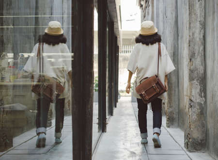 Young fashion girl with leather bag at alleywayの写真素材