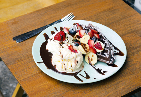Ice cream, banana, strawberry, raspberry, chocolate waffles with chocolate sauce の写真素材