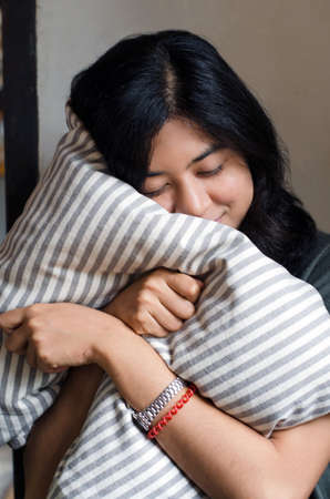 Young cute girl resting on soft pillowの写真素材