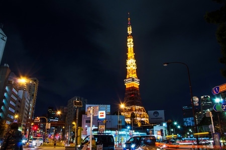Tokyo, Japan - November 28, 2013: Busy street at night with Tokyo Tower in the distance in Tokyo,...