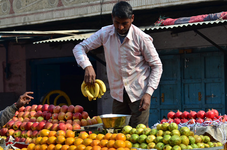 Jodhpur, India - January 1, 2015: Unidentified Indian man selling fruits at street market in India. Food hawkers in India are generally unaware of standards of hygiene and cleanliness.のeditorial素材