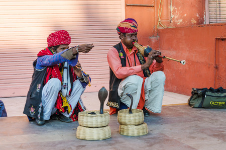 Jaipur, India - December 29, 2014: Snake charmer is playing the flute for the cobra in front of the Winds Palace on December 29, 2014 in Jaipur, Indiaのeditorial素材