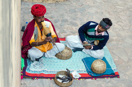 Jaipur, India - December 29, 2014: Snake charmer is playing the flute for the cobra in the Amber Fort near Jaipur on December 29, 2014 in Jaipur, Indiaのeditorial素材