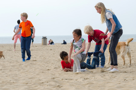 The Hague, Netherlands - May 8, 2015: Children playing at the beach, Scheveningen district in The Hague, Netherlands. Scheveningen is a modern seaside resort with a long sandy beach, an esplanade, a pier, and a lighthouse.のeditorial素材
