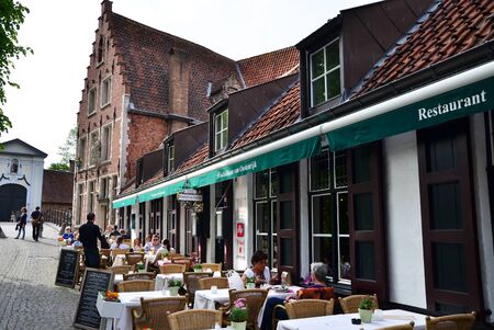 Bruges, Belgium - May 11, 2015: Tourist at outdoor cafeteria in Bruges, Belgium. Bruges is the capital and largest city of the province of West Flanders in the Flemish Region of Belgium.のeditorial素材