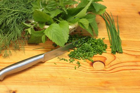 Herbs in basket - dill, balm, oregano and chives on wooden boardの写真素材