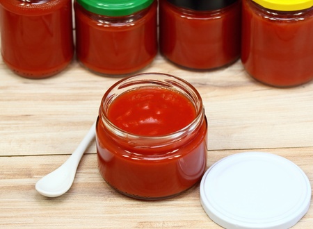 Homemade preservation of ketchup, jars of ketchup at backgroundの写真素材