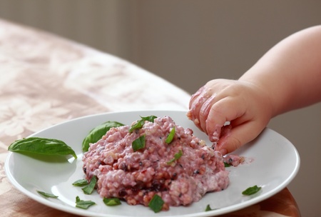 Baby  hand trying to eat oatmeal porridgeの写真素材