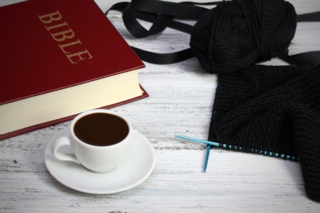 In memory of the deceased, black knitting, ribbon, coffee and bible, All Souls Day, soft focus on needlesの写真素材